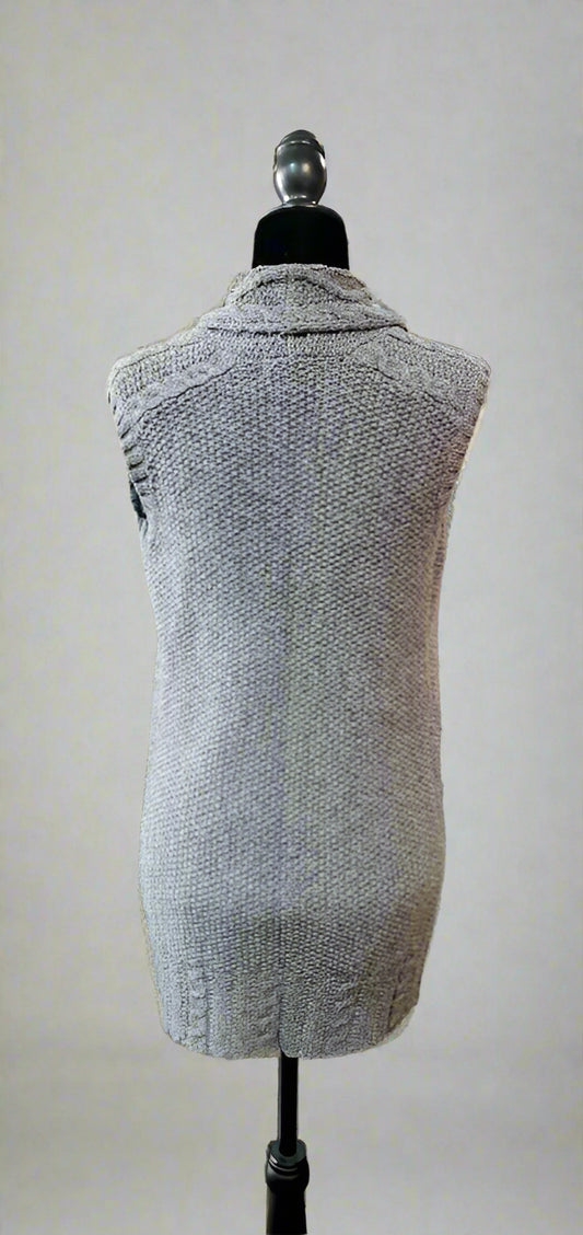 Gray vest on a mannequin in a store setting with racks of clothes in the background.