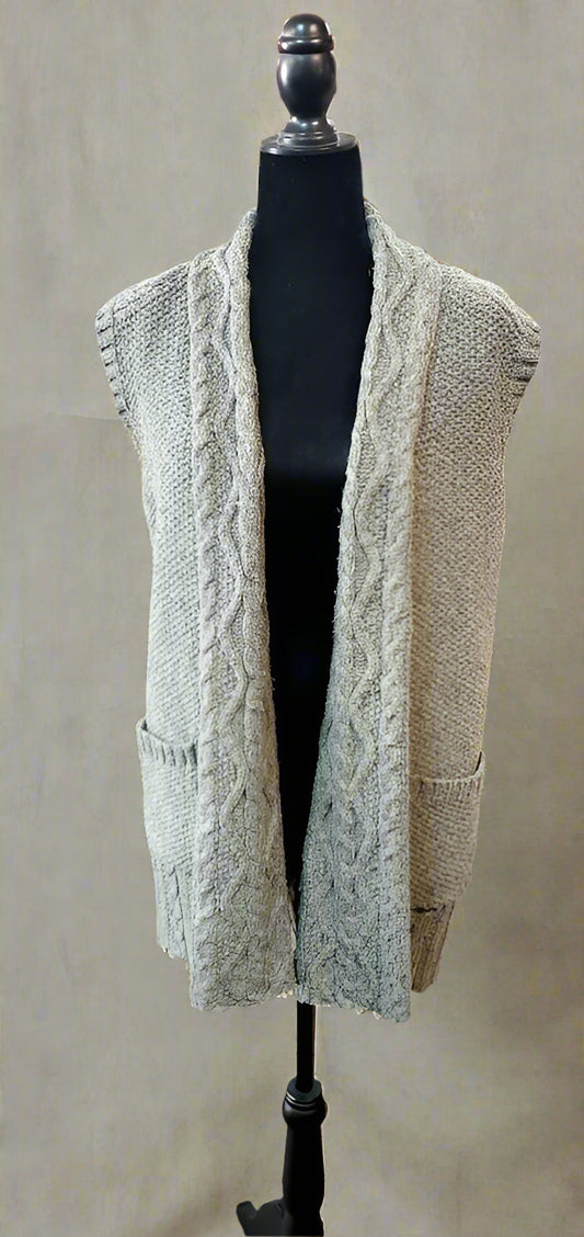 Green cable knit cardigan on a mannequin in a store setting