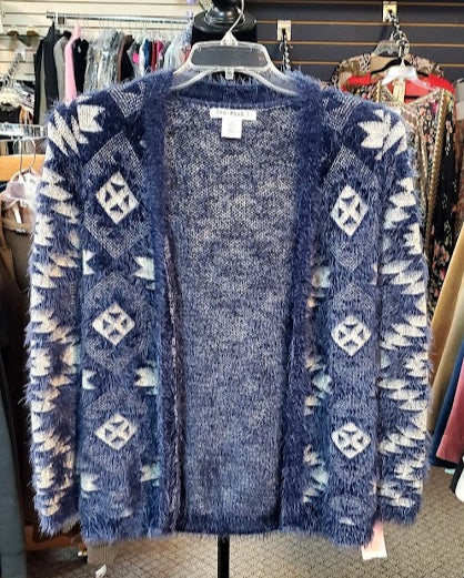 Blue patterned cardigan on a mannequin in a store setting