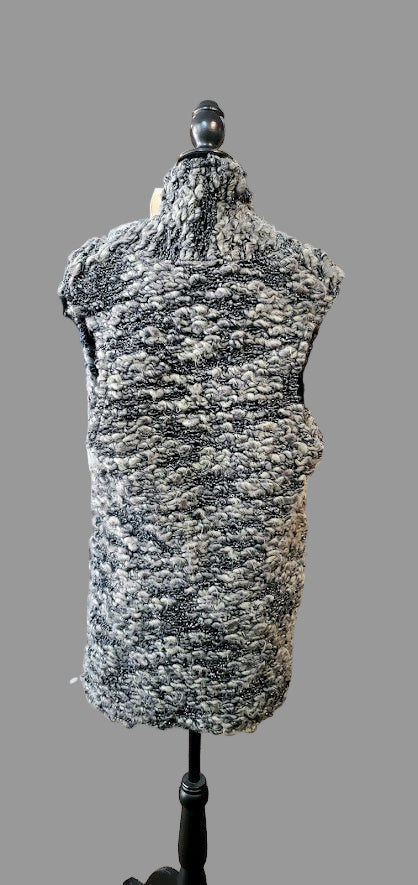 Mannequin wearing a textured gray garment in a clothing store setting