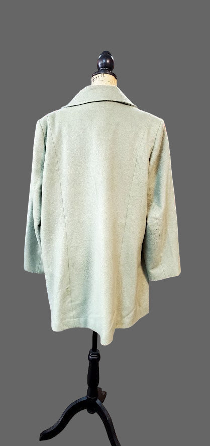 Light green coat on a mannequin in a clothing store setting