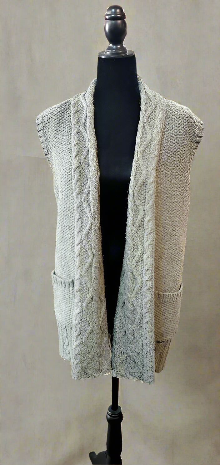 Green cable knit cardigan on a mannequin in a store setting
