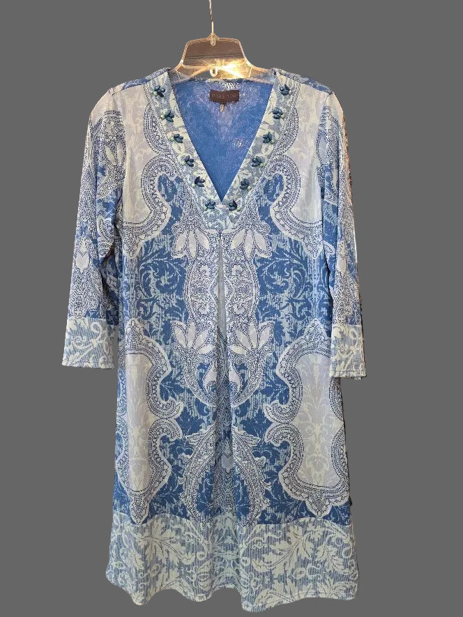 Blue and white patterned dress hanging on a rack in a store setting